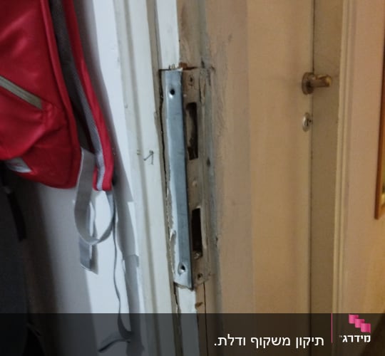מנעול דלת מתכת על משקוף עץ לבן